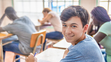 Pädagogik: Glücklicher Schüler im Klassenzimmer