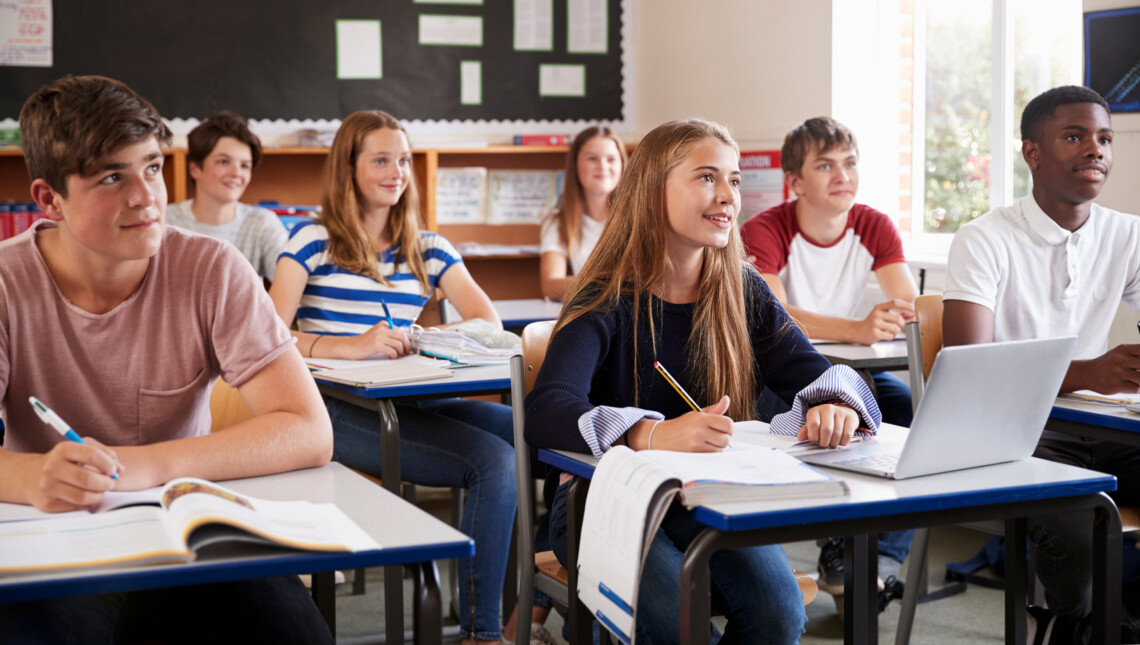 Schüler*innen einer Klasse schauen erwartungsvoll nach vorne