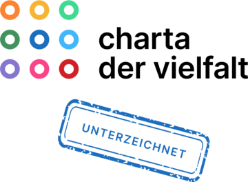 Hände verschiedener Hautfarben fassen sich am Handgelenk