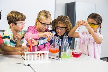 Vier Schülerinnen und Schüler machen ein Experiment im Chemieunterricht