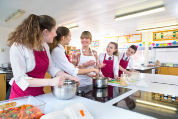 High school student cooking during a home economics class with their teacher.; Shutterstock ID 1878694264; client: 1157; job: picturemaxx; other: publishing-support@cornelsen.de; purchase_order: picturemaxx
High school student cooking during a home economics class with their teacher.