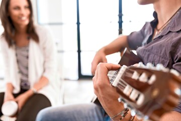 Lehrerin mit Gitarrenschüler im Musikunterricht