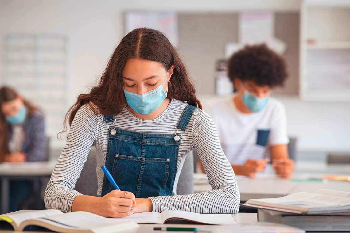 Schülerin mit Maske im Klassenzimmer