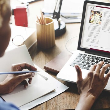 Lehrerin mit Psychologie-Lehrwerk am Laptop