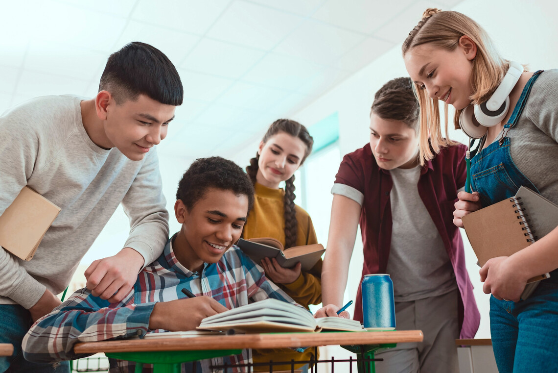 Schüler*innen schauen gemeinsam auf einen Tisch