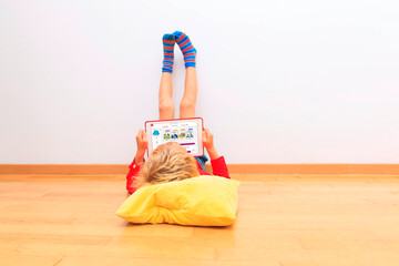 Digitale Didaktik: Kind mit Tablet in entspannter Haltung